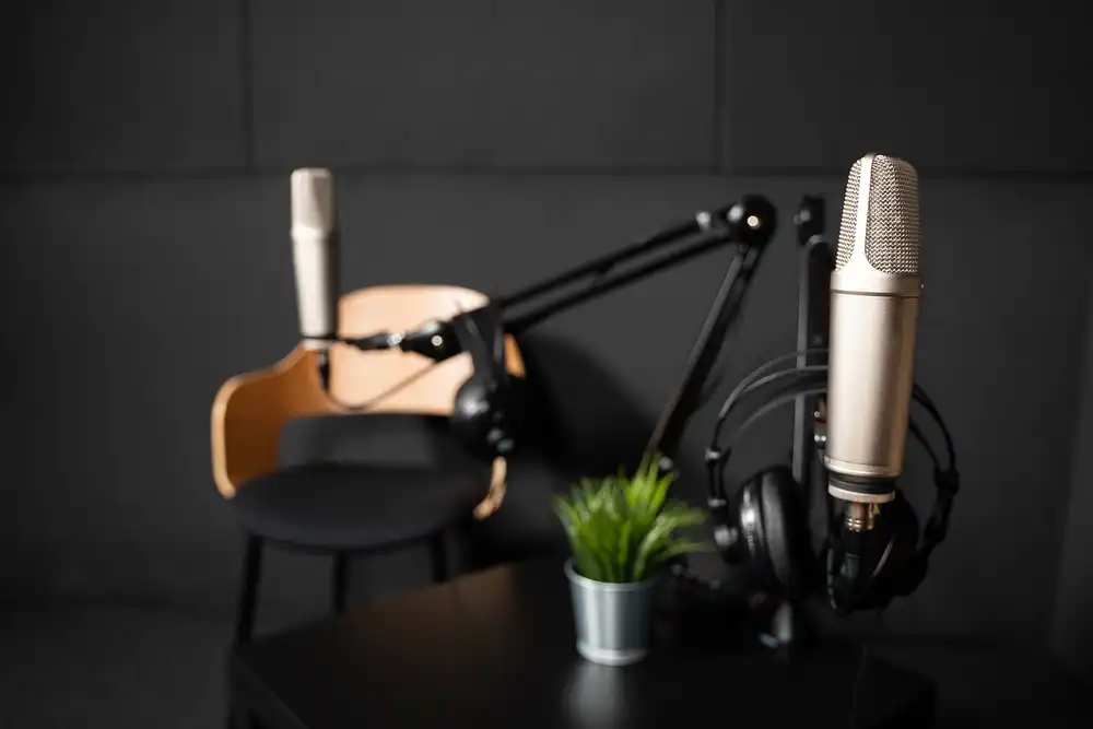 Dwa mikrofony podcastowe na statywach biurkowych w studiu nagraniowym